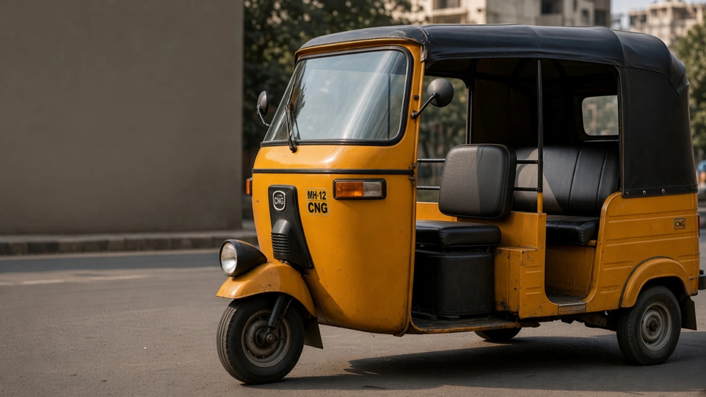 A yellow Bajaj auto-rickshaw parked on a Pune street
